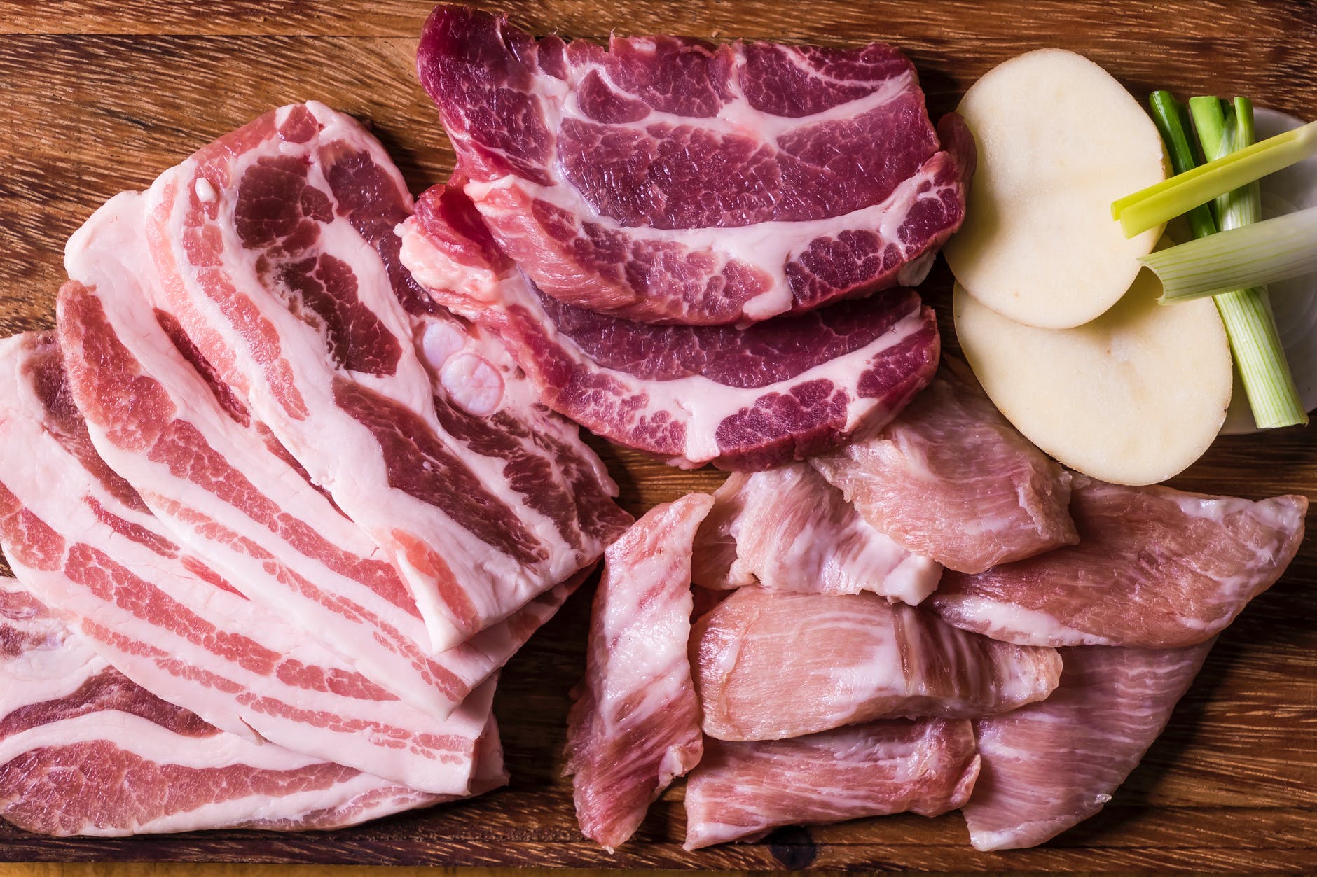 close up shot of slices of raw meat on a wooden chopping board